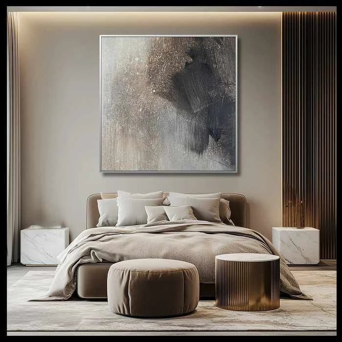 Gold and beige abstract art print adds warmth to a modern living room, complementing a grey textured wall and matching beige armchair.