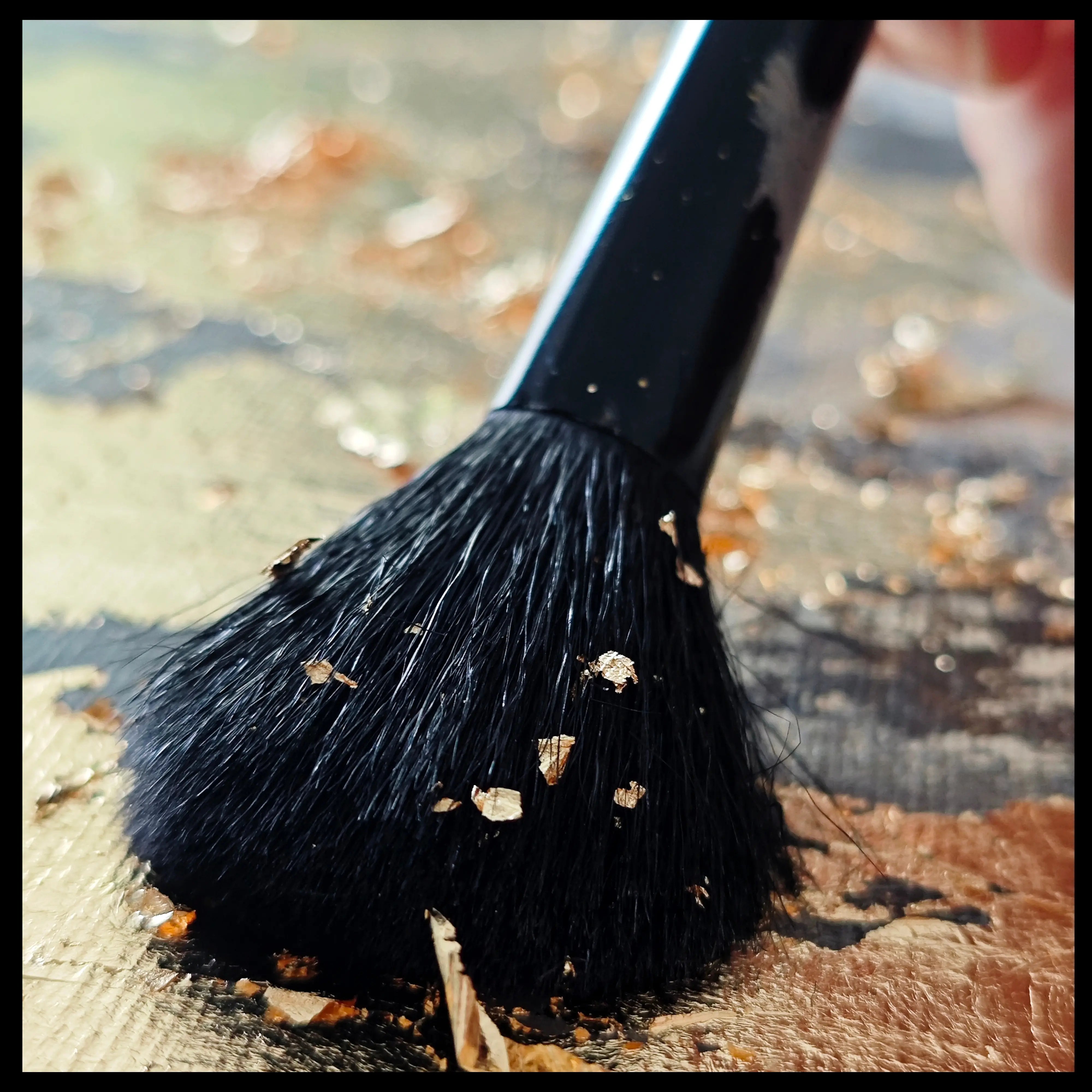 Close up on a gold painting and a brush on the canvas working with gold leaf in the artist studio of Anez Ka, contemporary artist. 